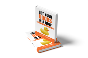 Two copies of 'Get Your Ducks in a Row' by Michon Henegar on a black background, symbolizing order, focus, and leadership.